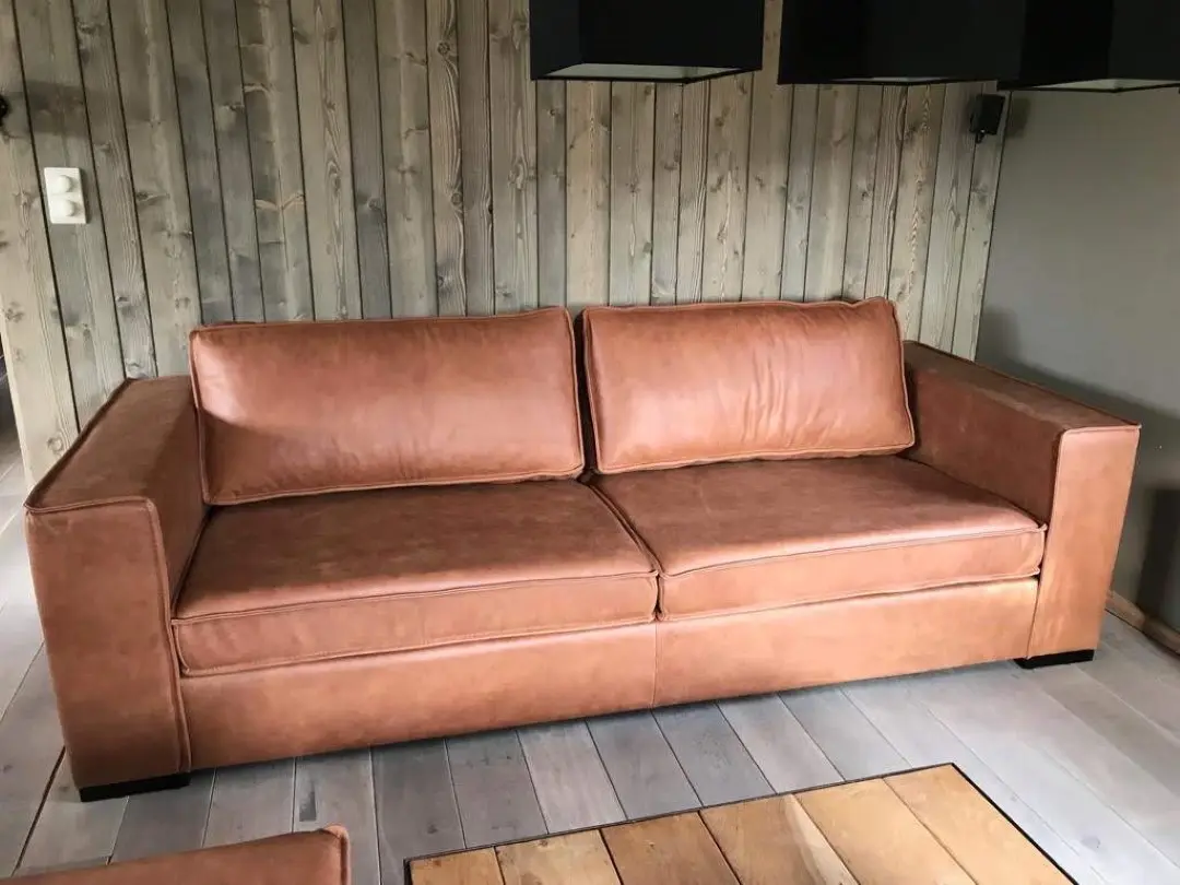 afbeelding van Leren 3.5-zits bank met Franse stiknaad en houten poten - bruin leer