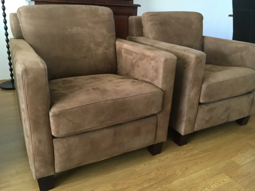 afbeelding van 2 leren fauteuils met houten poten - bruin leer