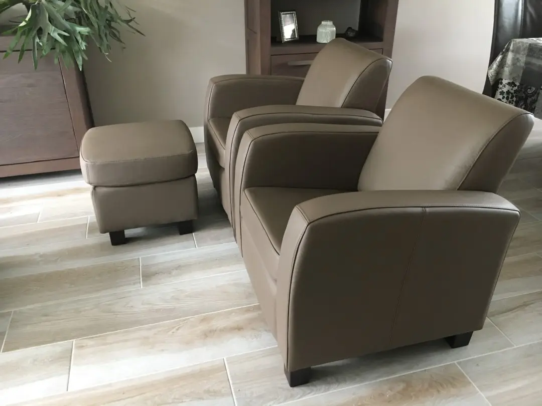 afbeelding van 2 leren fauteuils met houten poten - met hocker - bruin leer