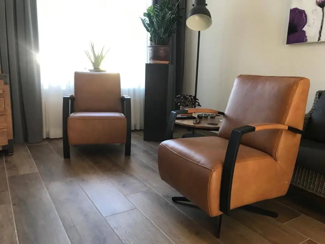 afbeelding van Set van 2 verschillende leren fauteuils met stalen poten - bruin leer