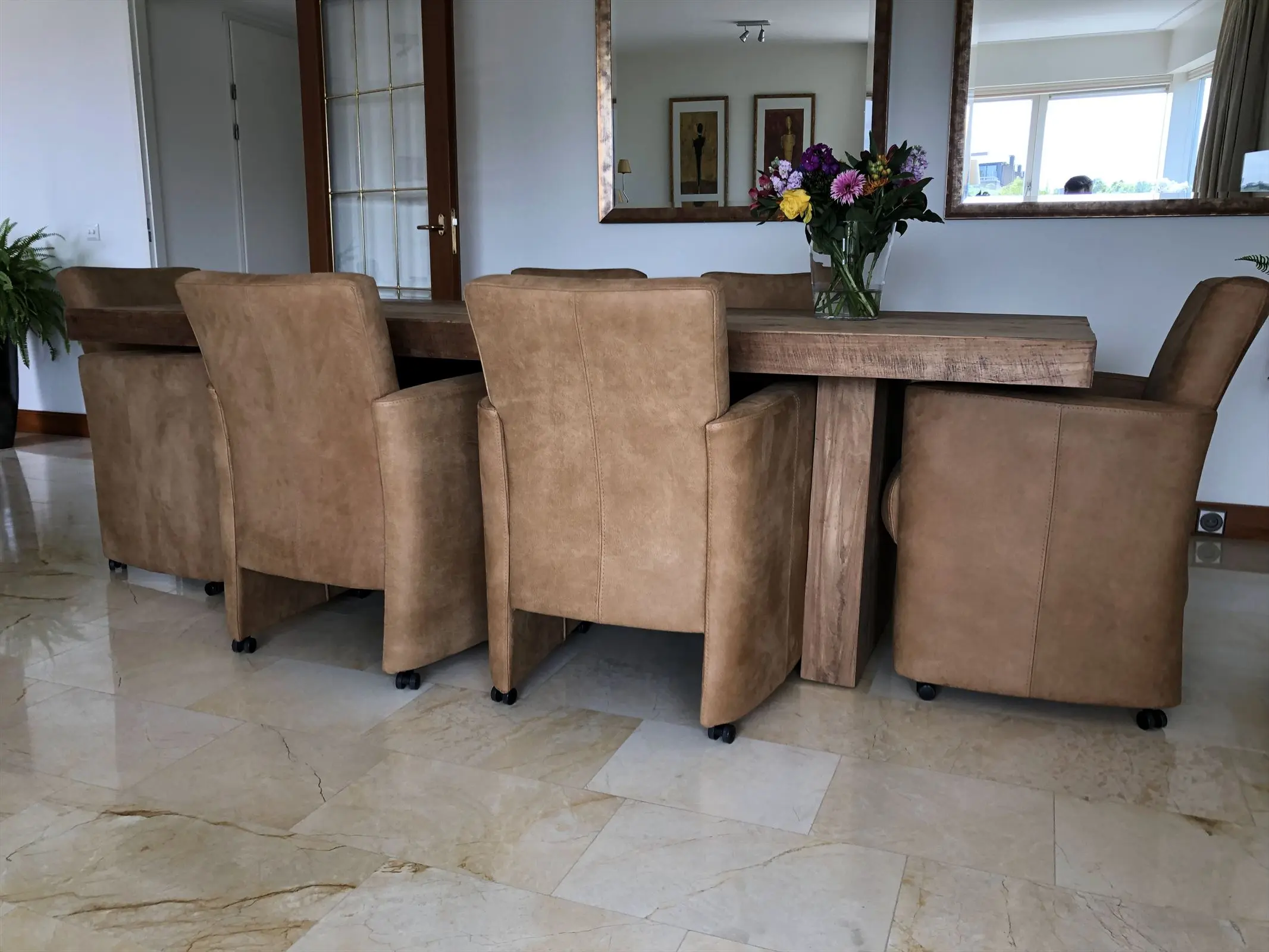 afbeelding van Set van 6 bruine leren eetkamerfauteuils met armleuning en wieltjes in bruin leer