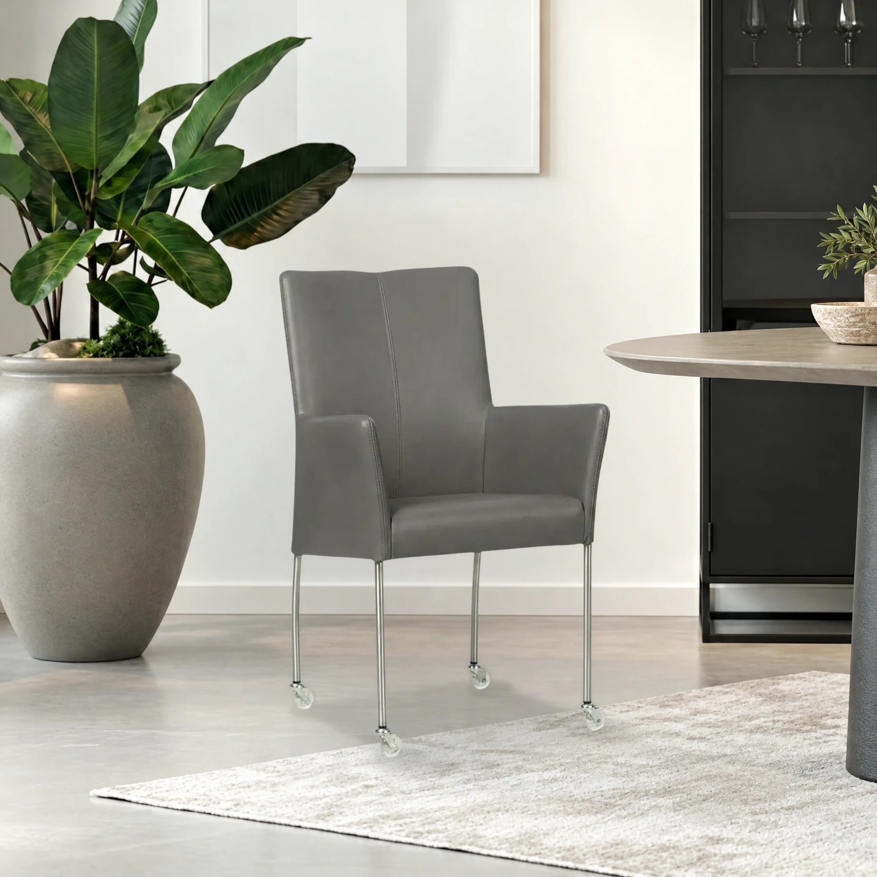 afbeelding van Leren eetkamerstoel Comfort met wieltjes en armleuning - Granada Steel (grijs) - Poten staal rond RVS
