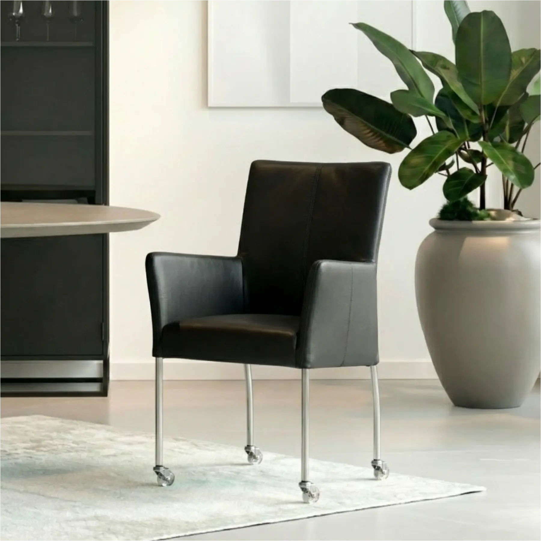 afbeelding van Leren eetkamerstoel Comfort met wieltjes en armleuning - Hermes Antracite (donkergrijs) - Poten staal rond RVS