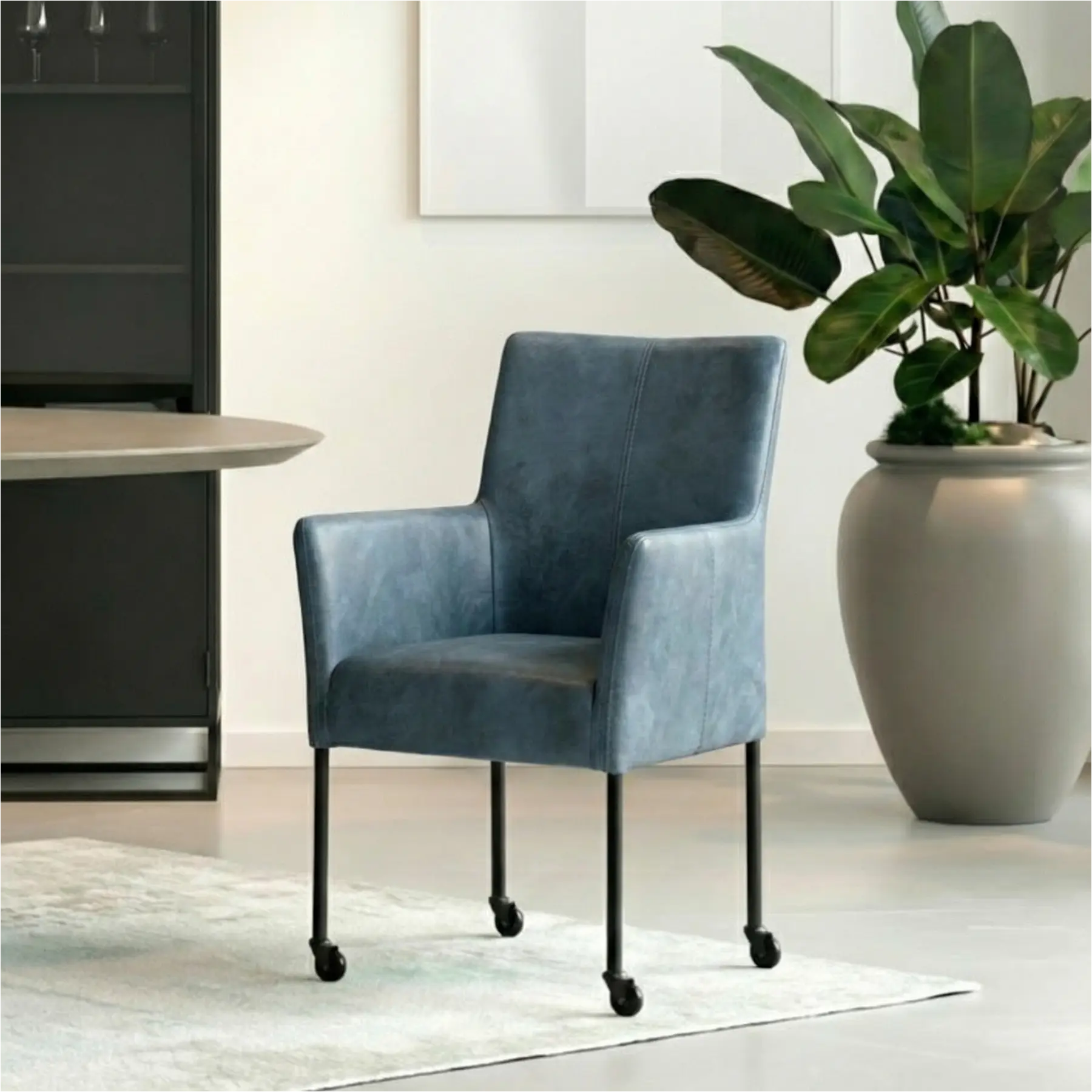 afbeelding van Leren eetkamerstoel Comfort met wieltjes en armleuning - Kenia Denim (blauw) - Poten staal rond zwart