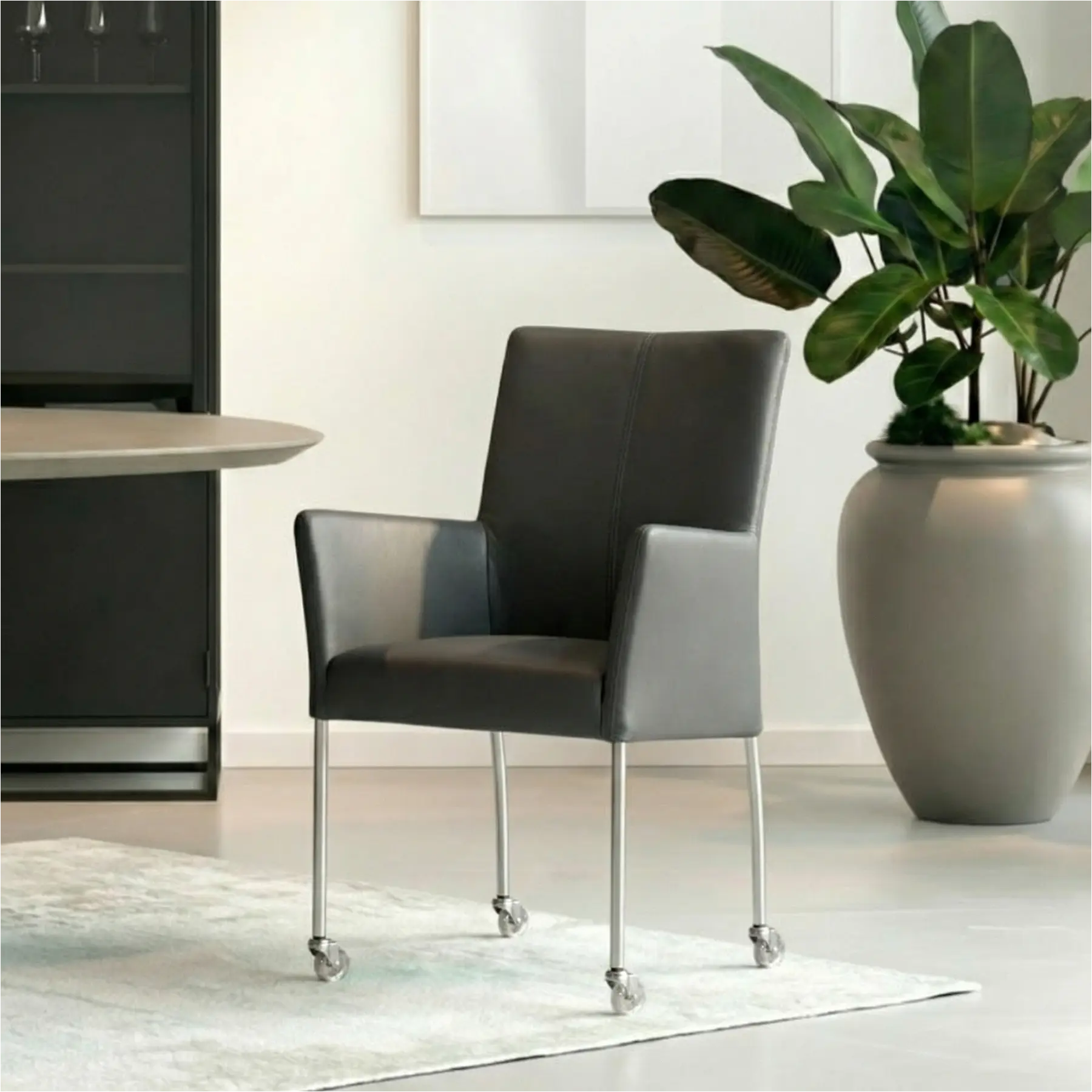 afbeelding van Leren eetkamerstoel Comfort met wieltjes en armleuning - Toledo Antracite (donkergrijs) - Poten staal rond RVS