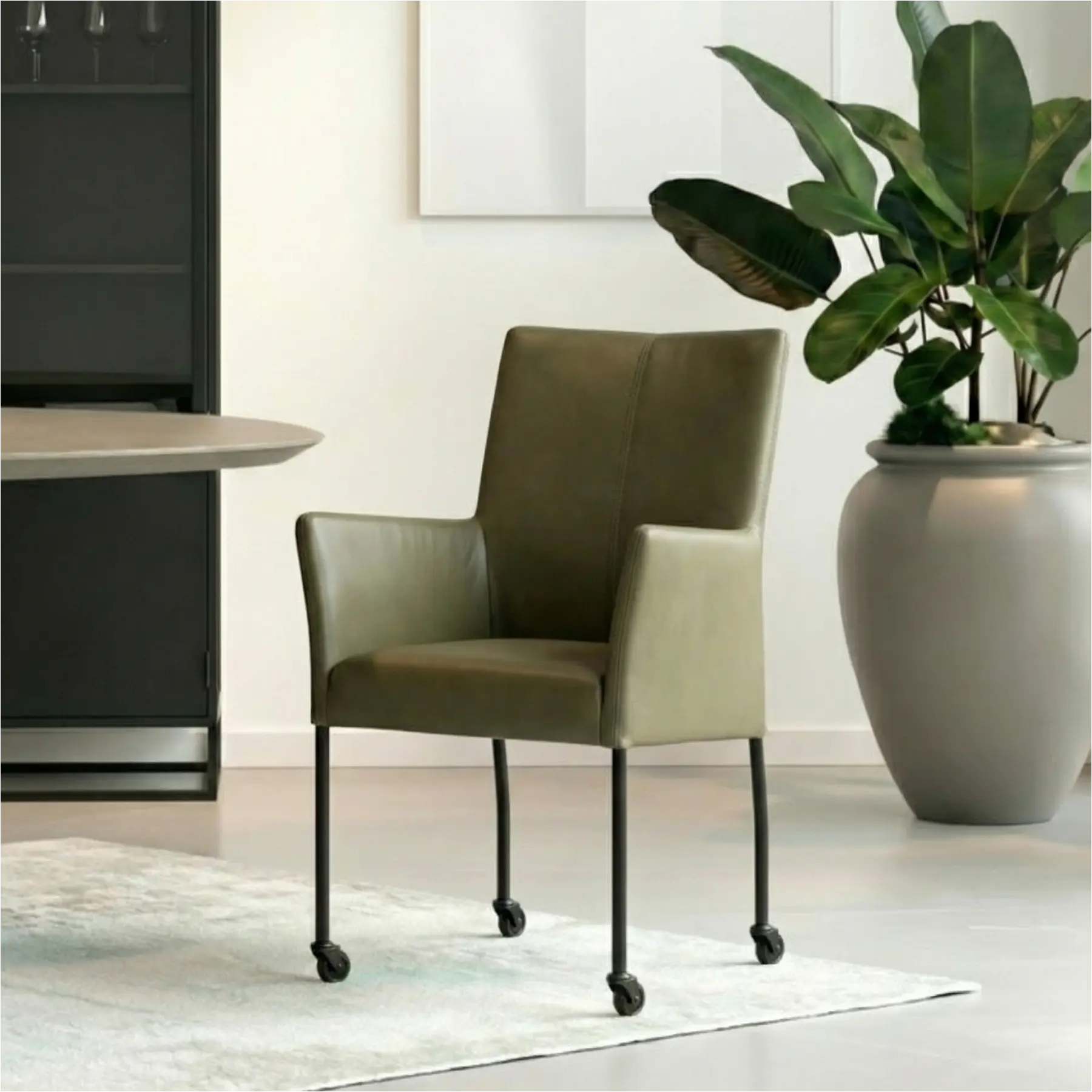 afbeelding van Leren eetkamerstoel Comfort met wieltjes en armleuning - Toledo Olive (olijf/goen) - Poten staal rond zwart