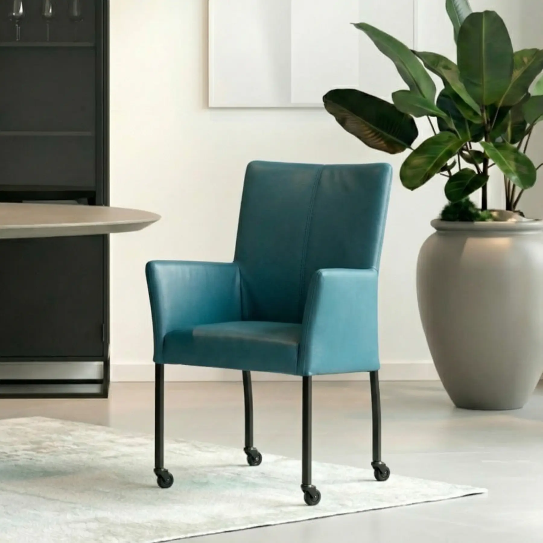 afbeelding van Leren eetkamerstoel Comfort met wieltjes en armleuning - Toledo Turquoise (blauw) - Poten staal rond zwart