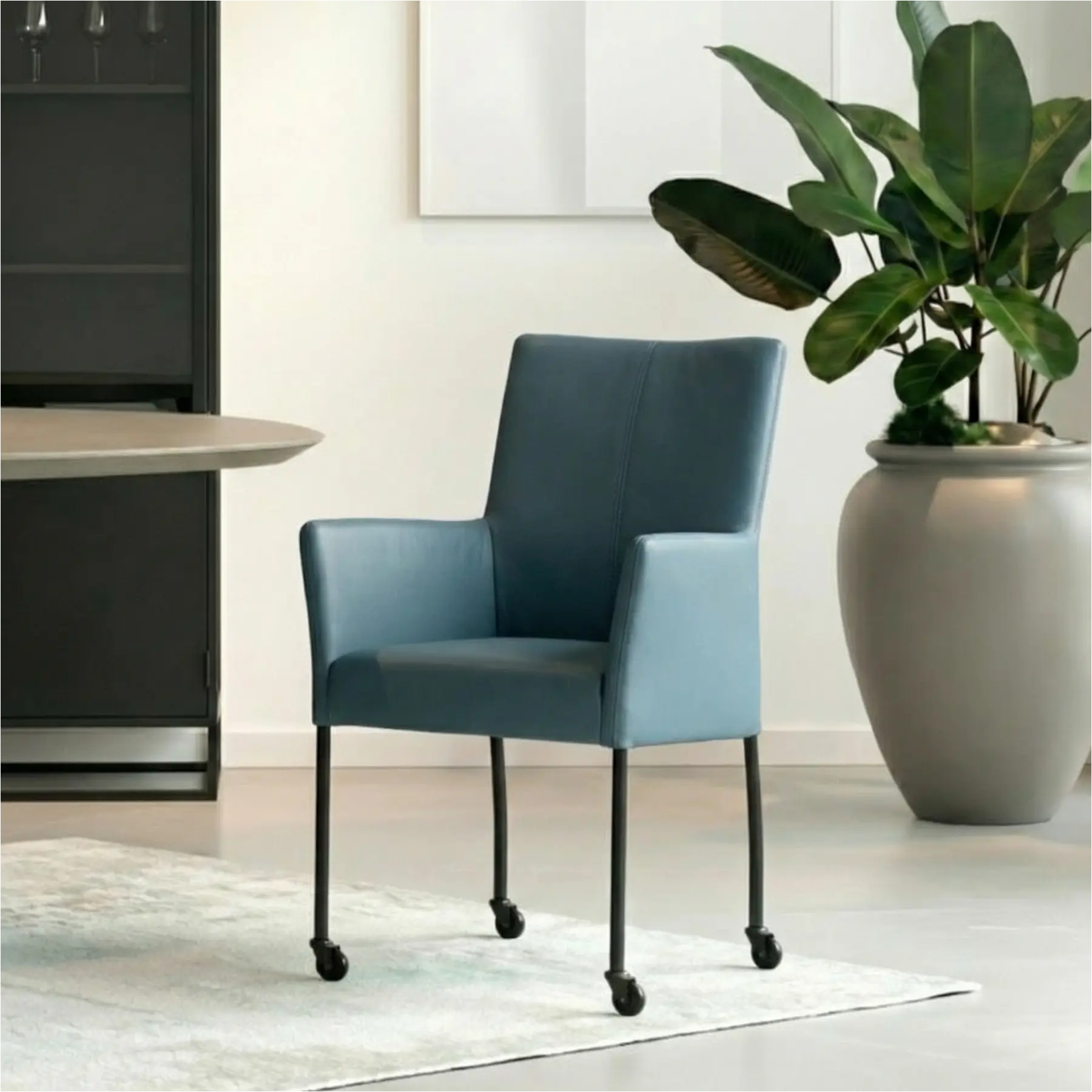 afbeelding van Leren eetkamerstoel Comfort met wieltjes en armleuning - Toledo Whale (blauw/grijs) - Poten staal rond zwart