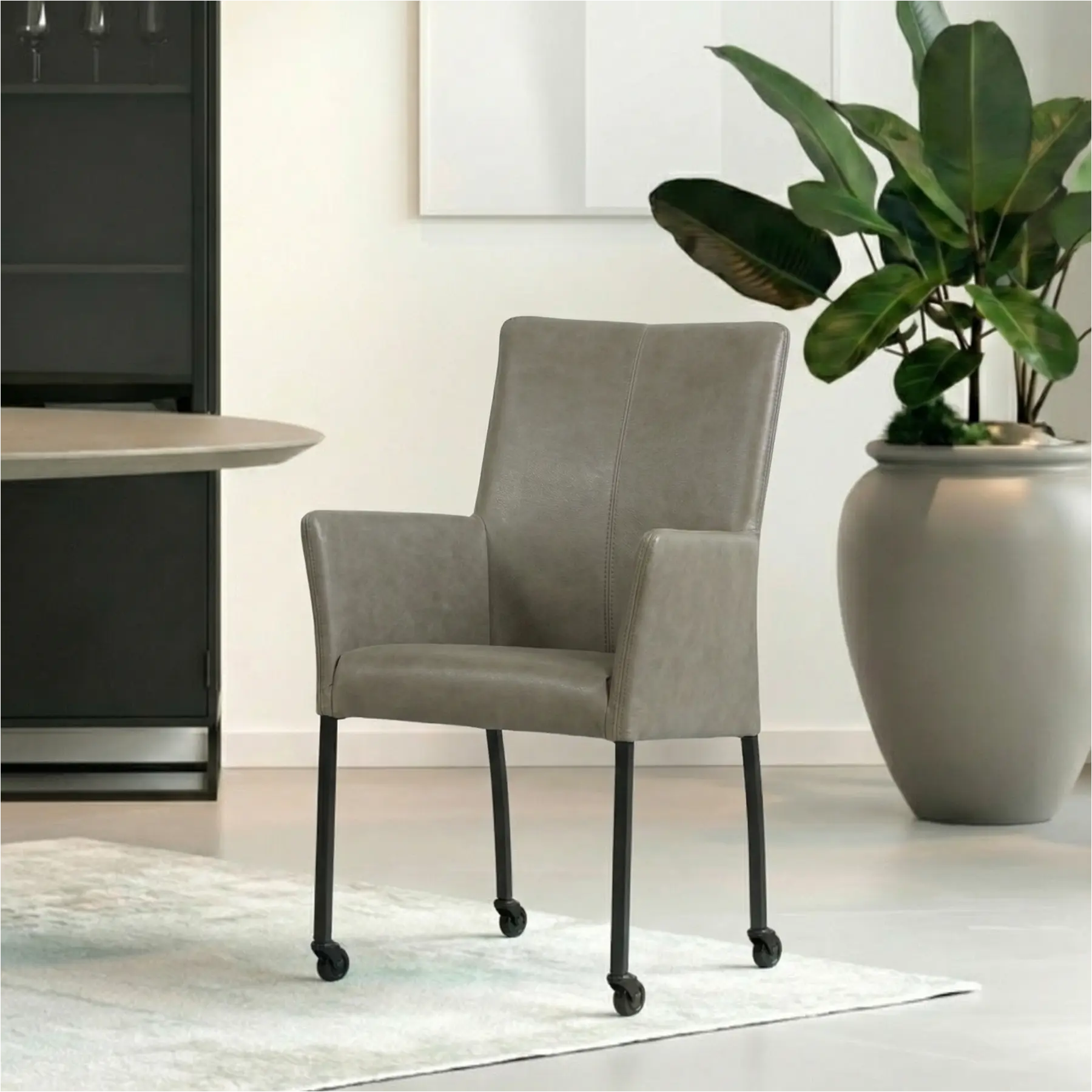afbeelding van Leren eetkamerstoel Comfort met wieltjes en armleuning - Vintage Stone (grijs) - Poten staal rond zwart