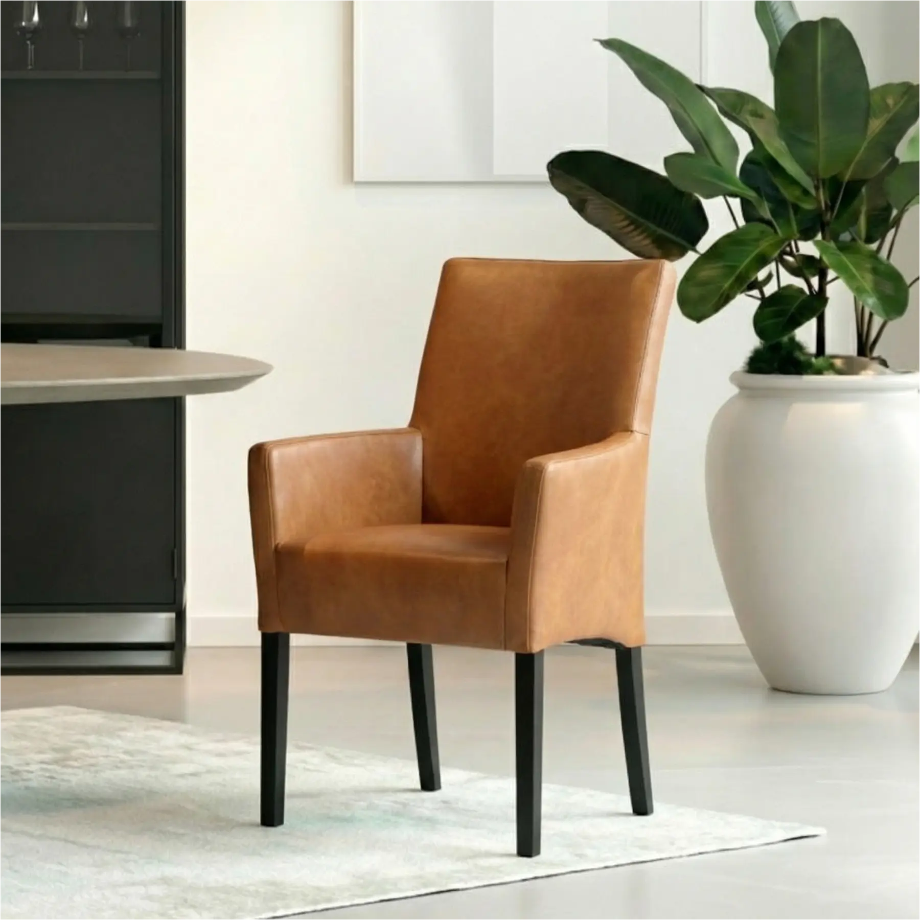 afbeelding van Leren eetkamerstoel Just met armleuning - Granada Sahara (cognac) - Poten hout zwart