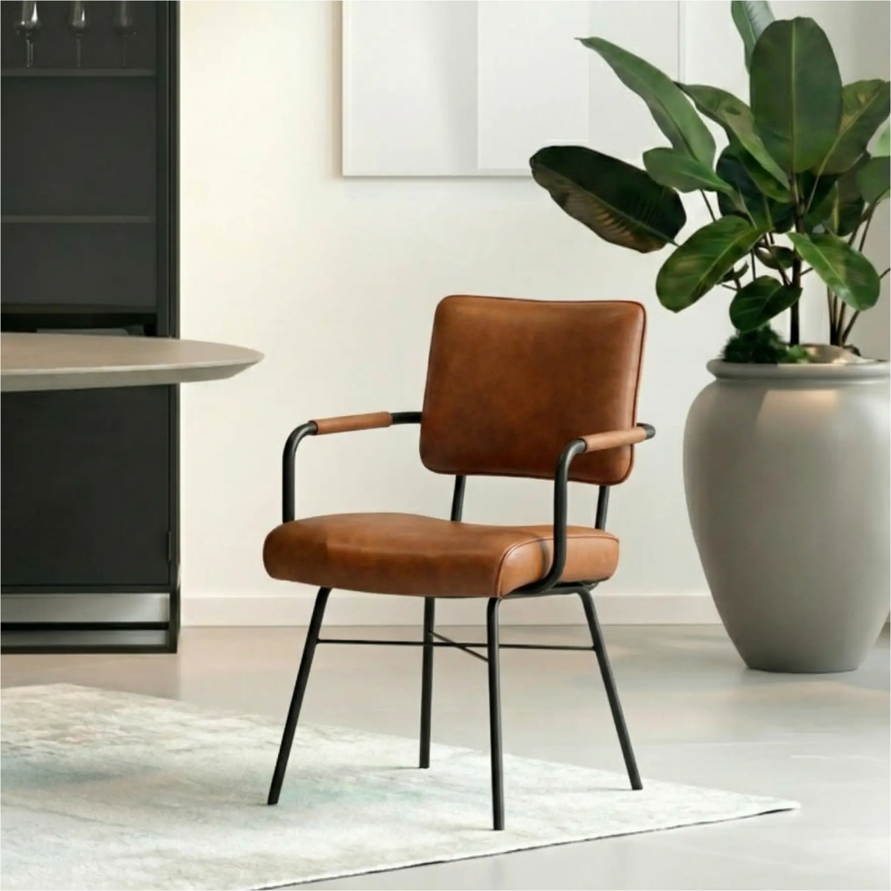 afbeelding van Leren eetkamerstoel Solid met armleuning - Granada Savannah (cognac) - Poten staal rond zwart